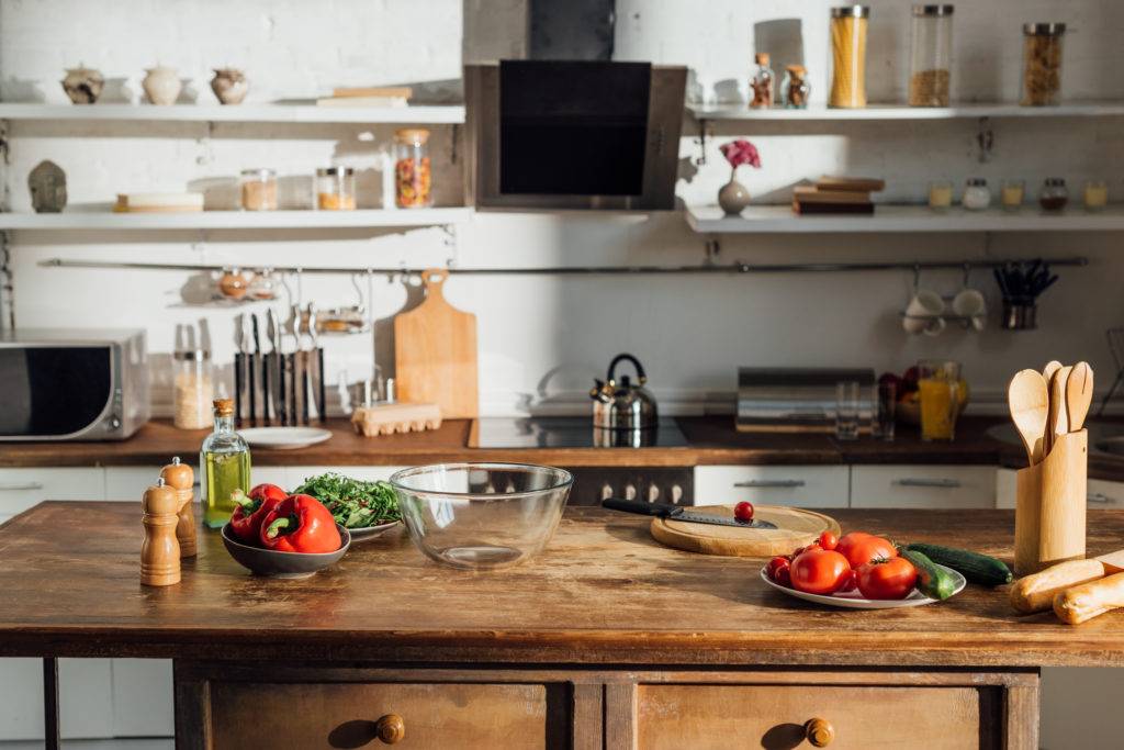 Butcher block kitchen island with chopping boards, vegetables and utensils