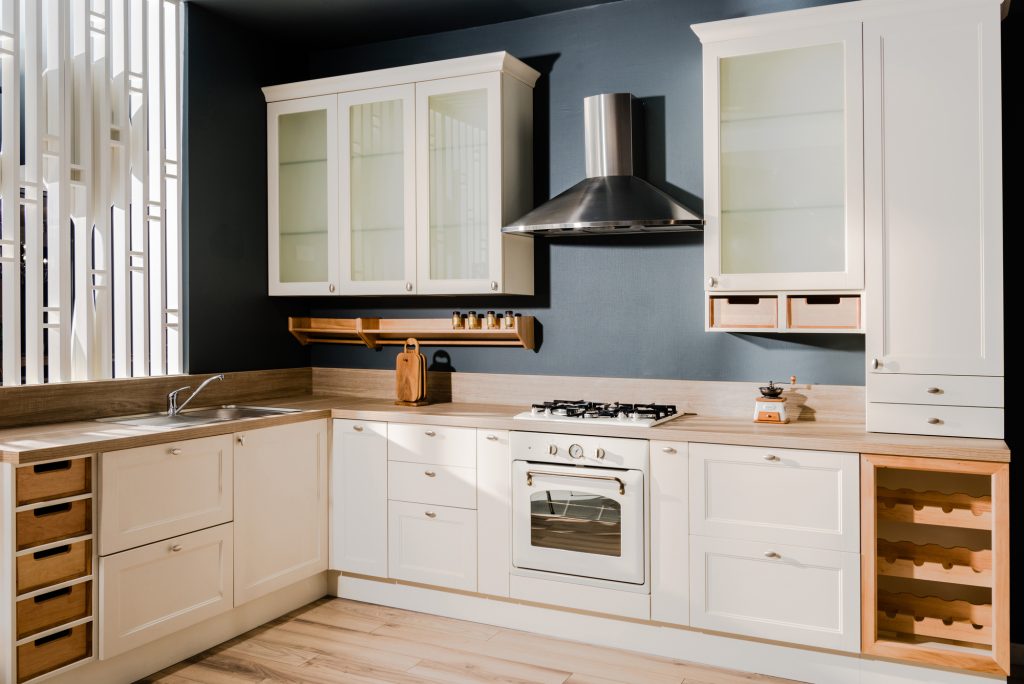 Bright kitchen with glass-fronted upper cabinets and a run of pale countertops