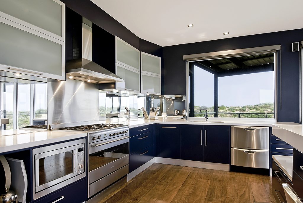 Large kitchen with navy cabinetry, stainless steel appliances and a timber floor