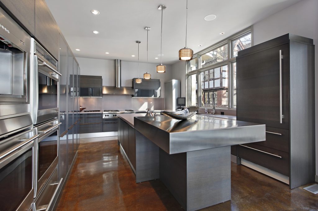 Dark modern kitchen with a stainless steel island, wall ovens and timber flooring