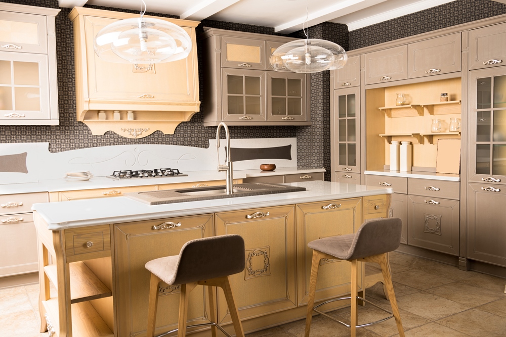 Cream and taupe kitchen with a breakfast island, dining chairs and pendant lights