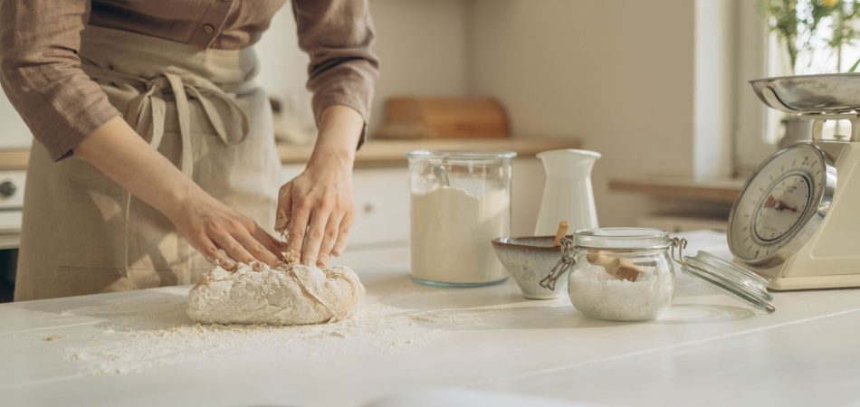 Baker kneading dough on a durable kitchen countertop