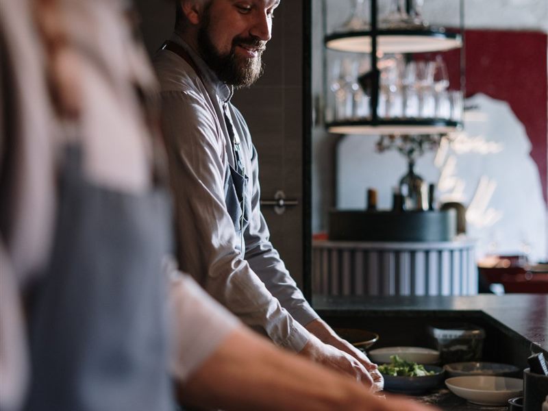 Cooks working side by side at an open kitchen counter