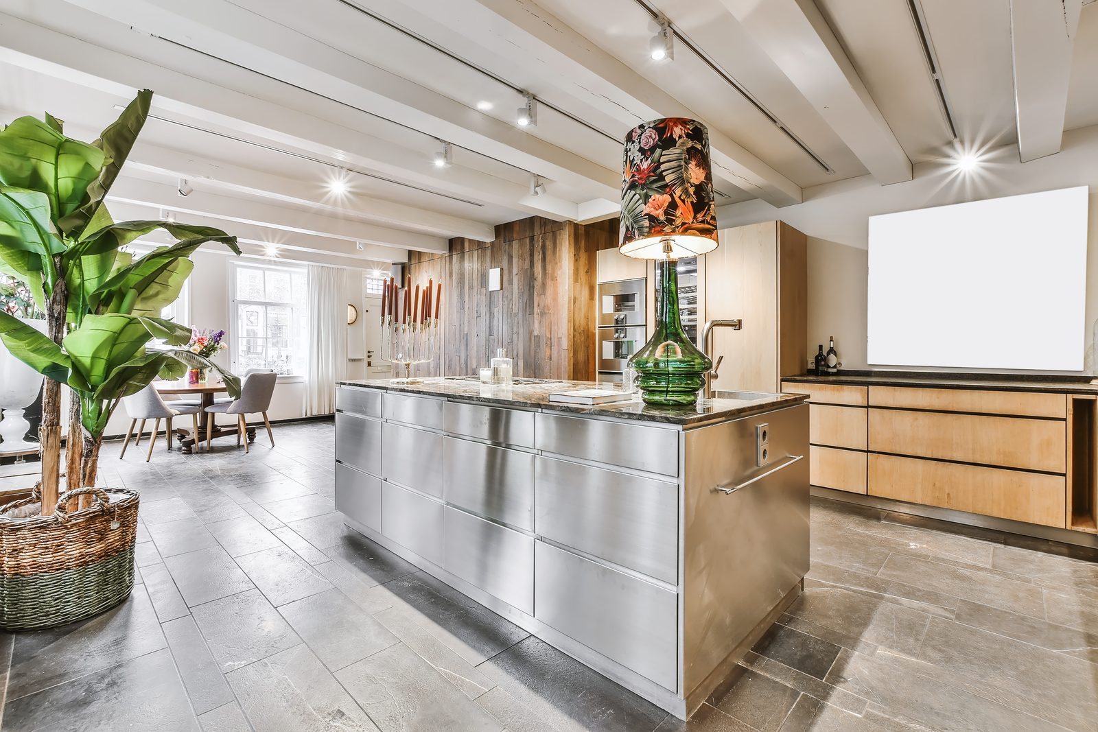 Open plan kitchen with a stainless steel island and full height timber cabinets