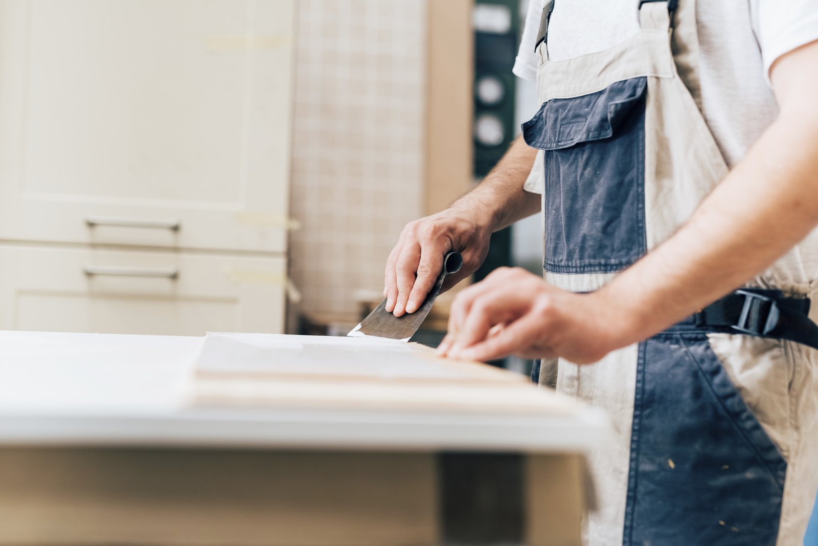 Installer smoothing the edge of a new countertop during a kitchen fit out