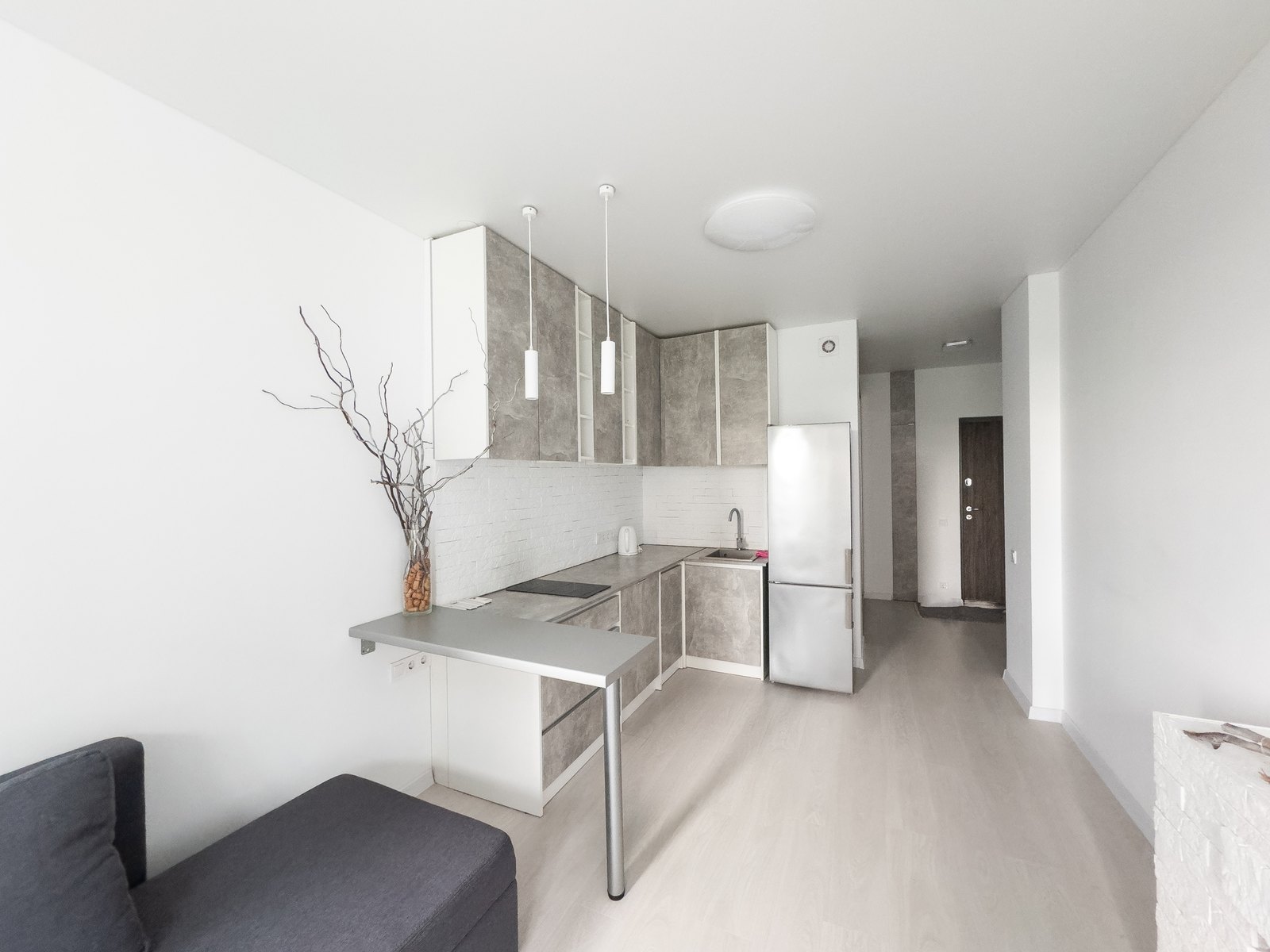 Compact white apartment kitchen with a slim counter run and a window at the end