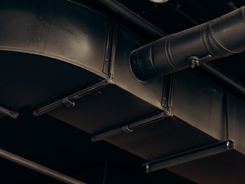 Round exhaust ductwork running along a ceiling