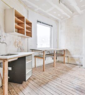Gutted kitchen after demolition with exposed plumbing and bare walls