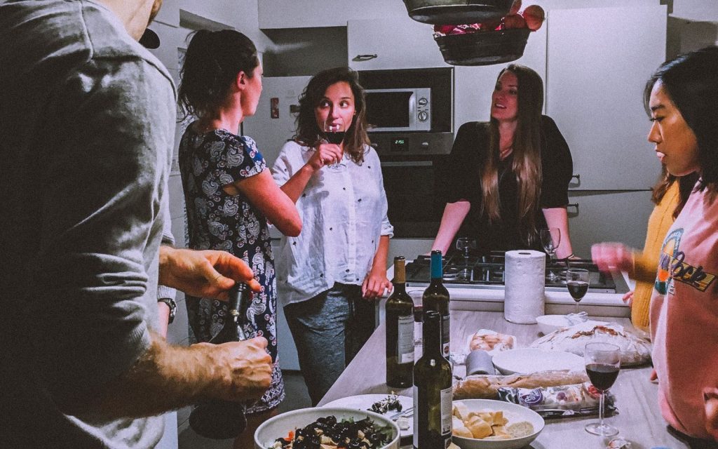 Friends gathered around a kitchen island with platters of food