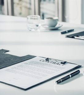 Warranty contract document on a table with a pen