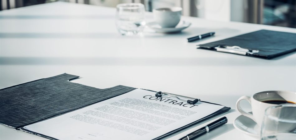 Warranty contract document on a table with a pen