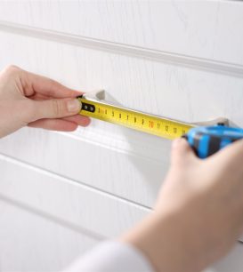 Tape measure held against a kitchen cabinet during a site visit