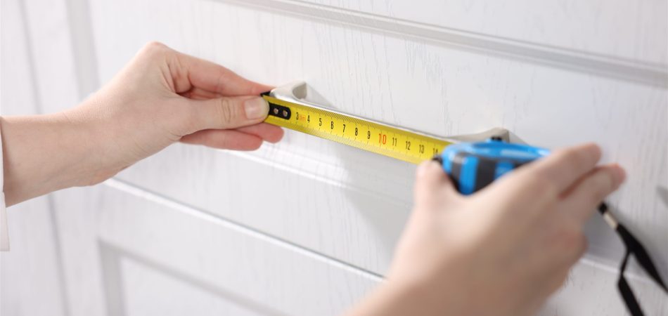 Tape measure held against a kitchen cabinet during a site visit