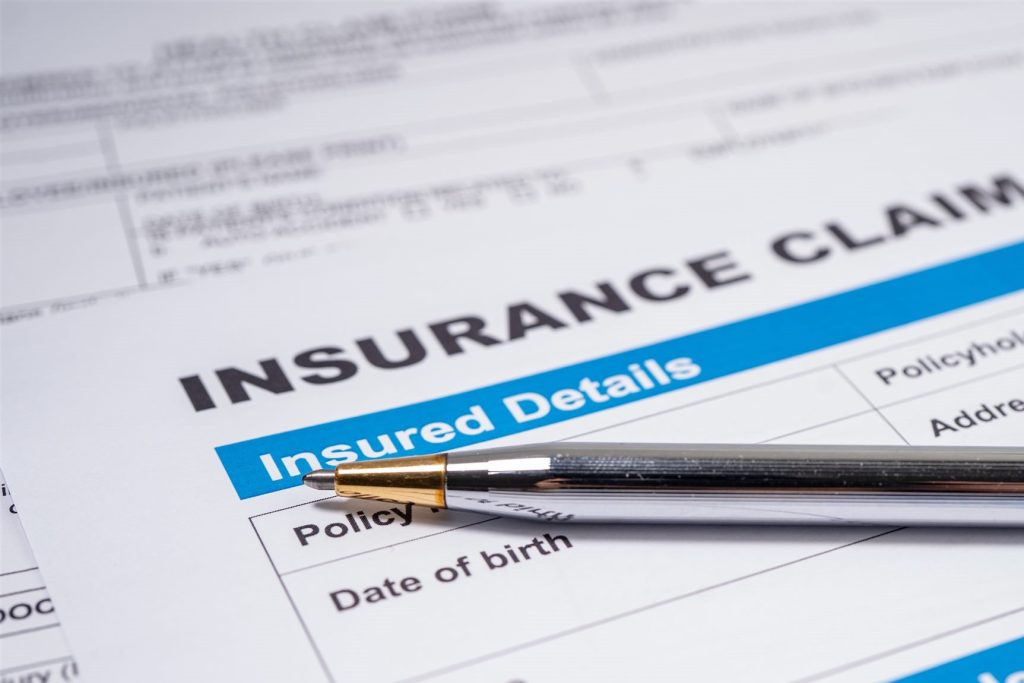 Insurance claim form for water damage on a desk with a pen