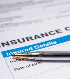 Insurance claim form for water damage on a desk with a pen