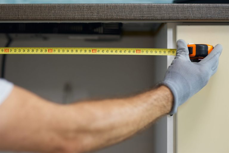Tape measure extended to check the ceiling height of a room